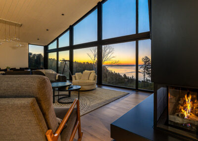 salon foyer fenestration toit cathedral au lever de soleil dans Charlevoix