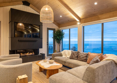 salon avec foyer et fenestration abondante fleuve saint-lurent en hiver dans à Baie Saint-Paul dans Charlevoix